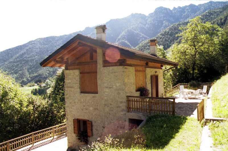 una pequeña casa en una colina con montañas en el fondo en Holiday home in Tiarno di Sotto 23505, en Tiarno di Sotto