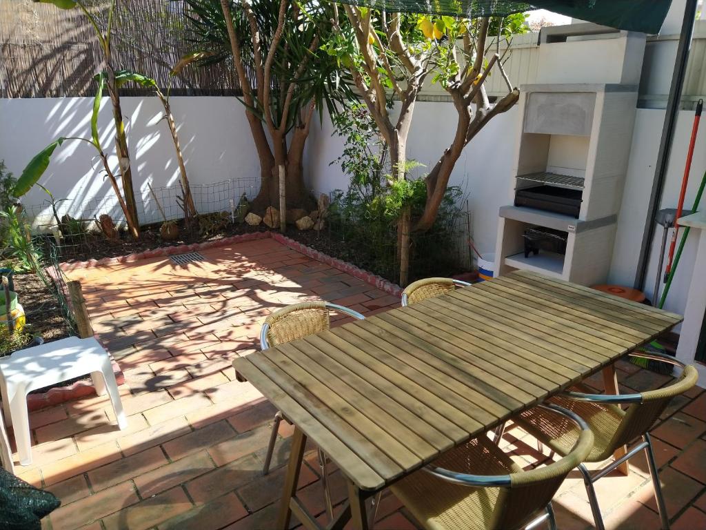 una mesa de madera y sillas en un patio en Villa Formosa, en Olhão