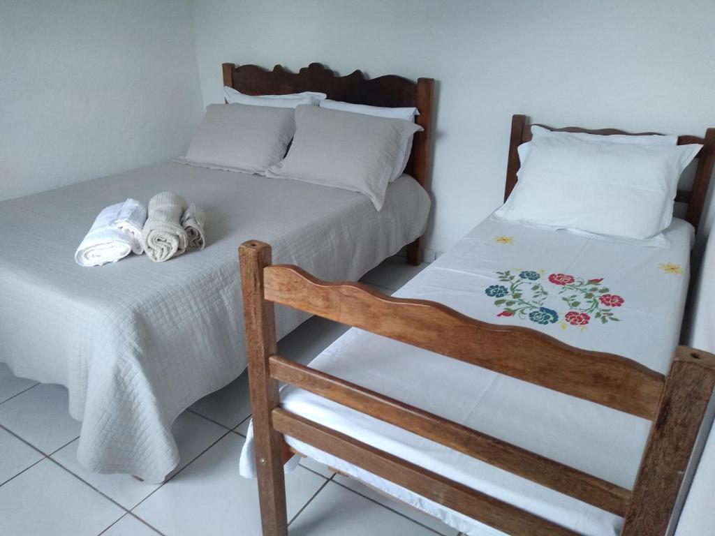 ein Schlafzimmer mit zwei Betten mit Handtüchern darauf in der Unterkunft Casa Vista para Serra in Tiradentes