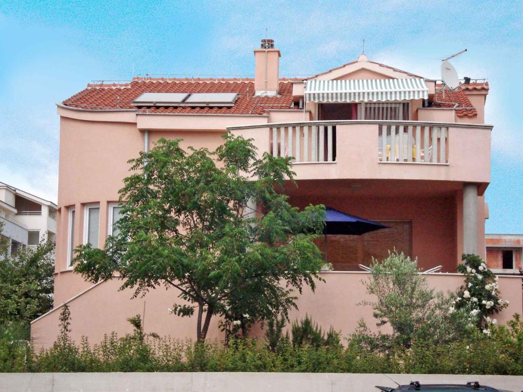 a pink house with a balcony on top of it at Apartment in Zadar/Zadar Riviera 7837 in Smirić