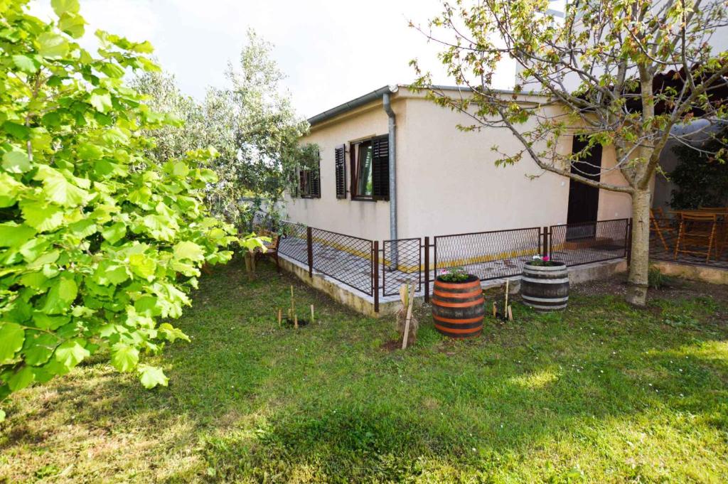 a house with two barrels in the yard at Holiday home in Pula/Istrien 17365 in Štinjan