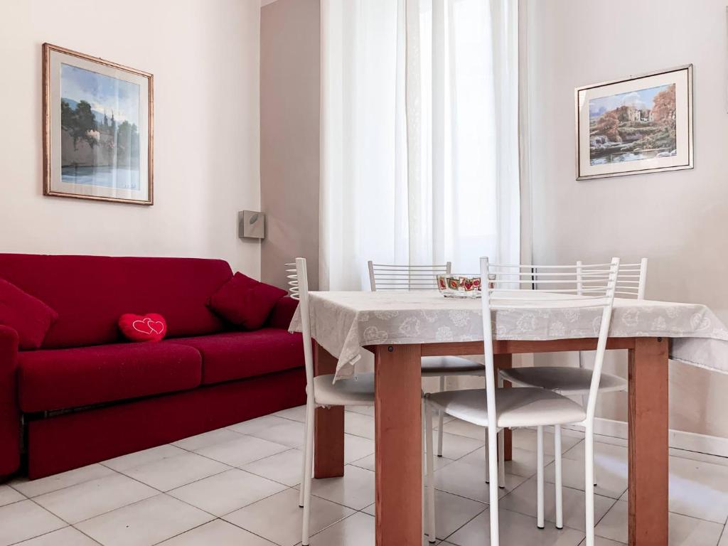 ヴェローナにあるNido Holiday Apartment Veronaのリビングルーム(テーブル、赤いソファ付)