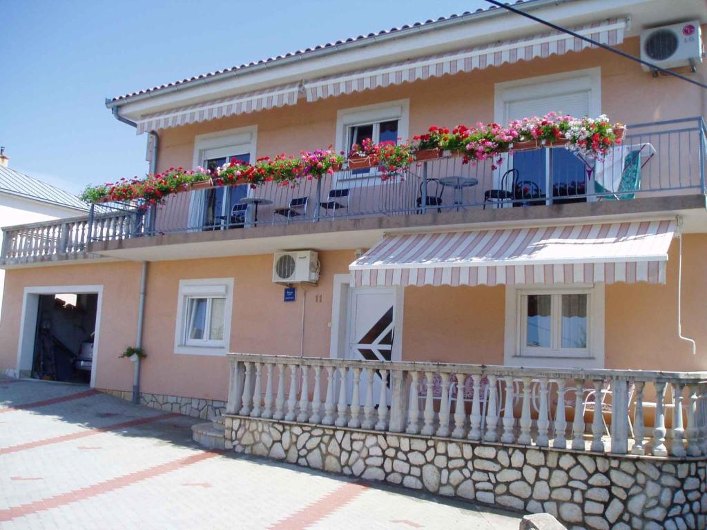 a building with a balcony with flowers on it at Two-Bedroom Apartment in Senj I in Nehaj