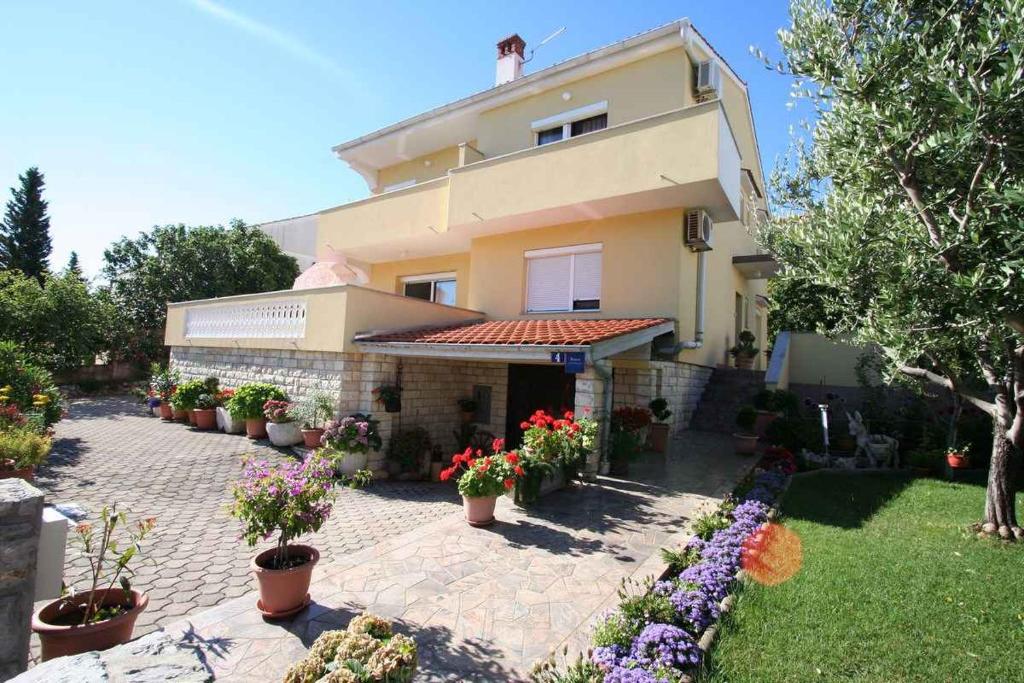 a large house with potted plants in front of it at Apartment in Silo/Insel Krk 13440 in Šilo