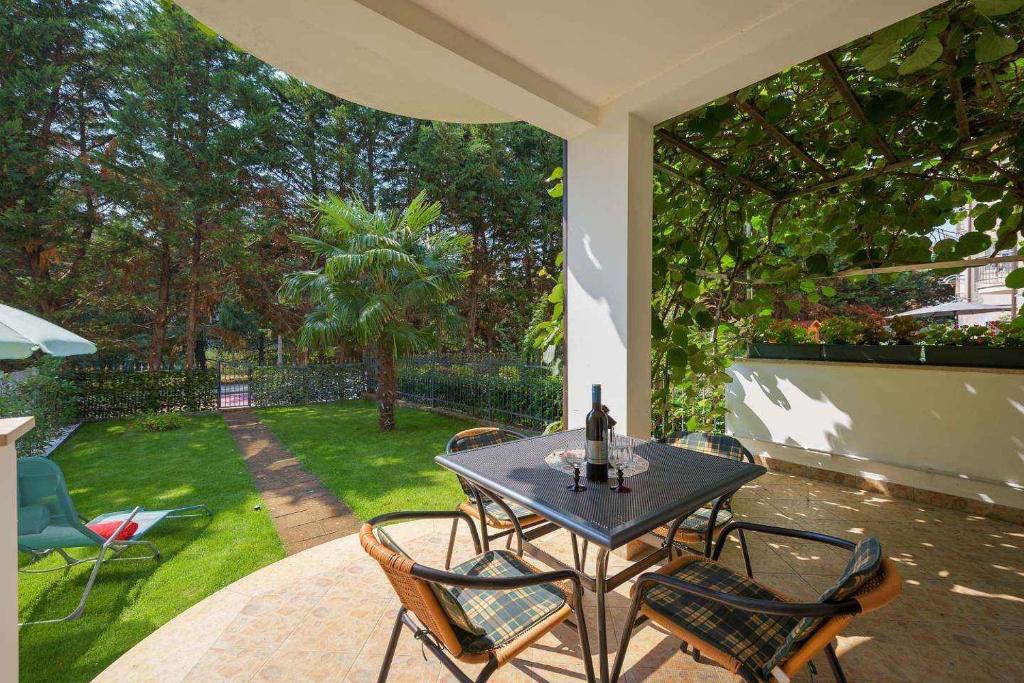 a table and chairs on a patio with a yard at Apartment in Porec/Istrien 10331 in Poreč
