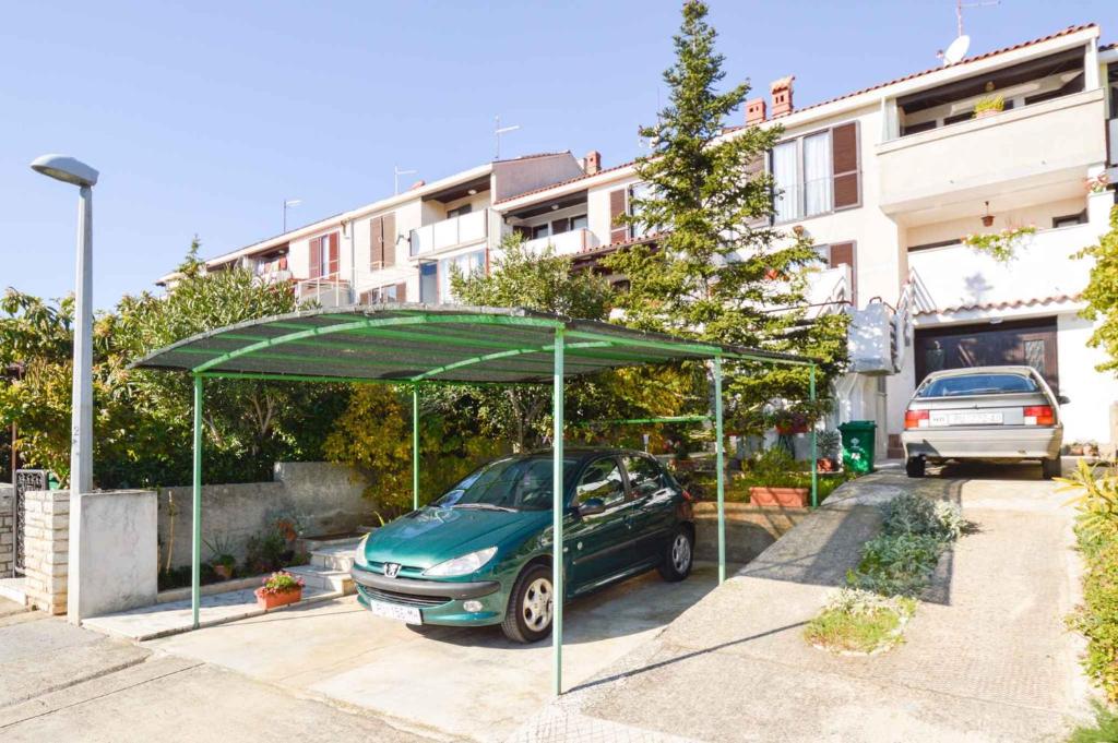 a car parked under a green umbrella in a parking lot at Apartment in Pula/Istrien 11064 in Vintijan