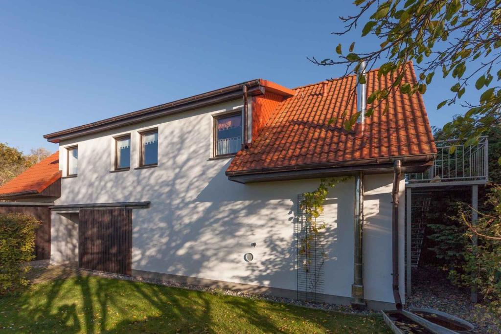 a white house with a red roof at Apartment Altenkirchen 4 in Altenkirchen