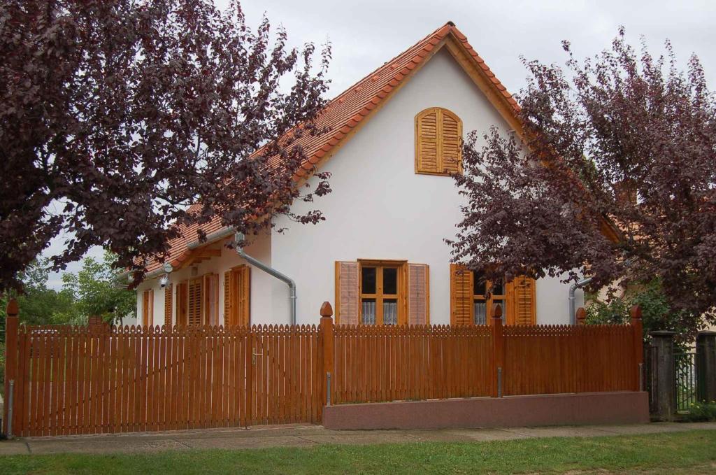 a small white house with a wooden fence at Apartment in Balatonbereny/Balaton 18075 in Balatonberény