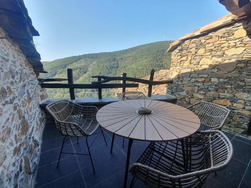 un patio con mesa, sillas y sombrilla en Casa do Talasnal Montanhas de Amor, en Lousã