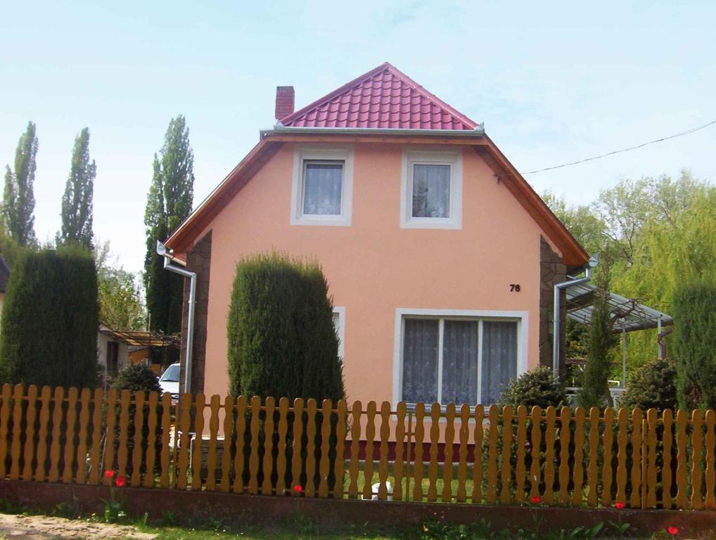 a pink house behind a wooden fence at Apartment in Balatonmariafürdo 19196 in Hegy