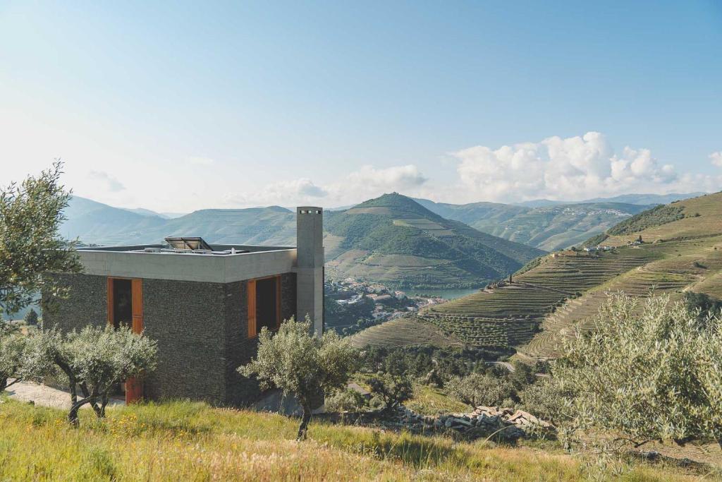 a building on the side of a hill with a valley at Casa do Arco by Douro Exclusive in São Cristóvão do Douro