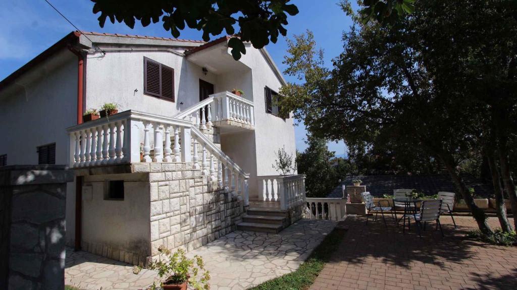 a white house with a balcony and a patio at Apartment Porat 22 in Porat