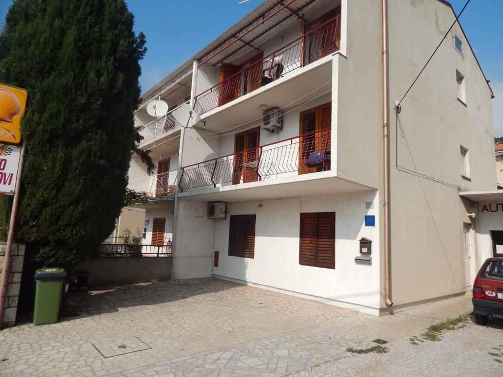 a white building with balconies on the side of it at Apartment Senj 1 in Senj