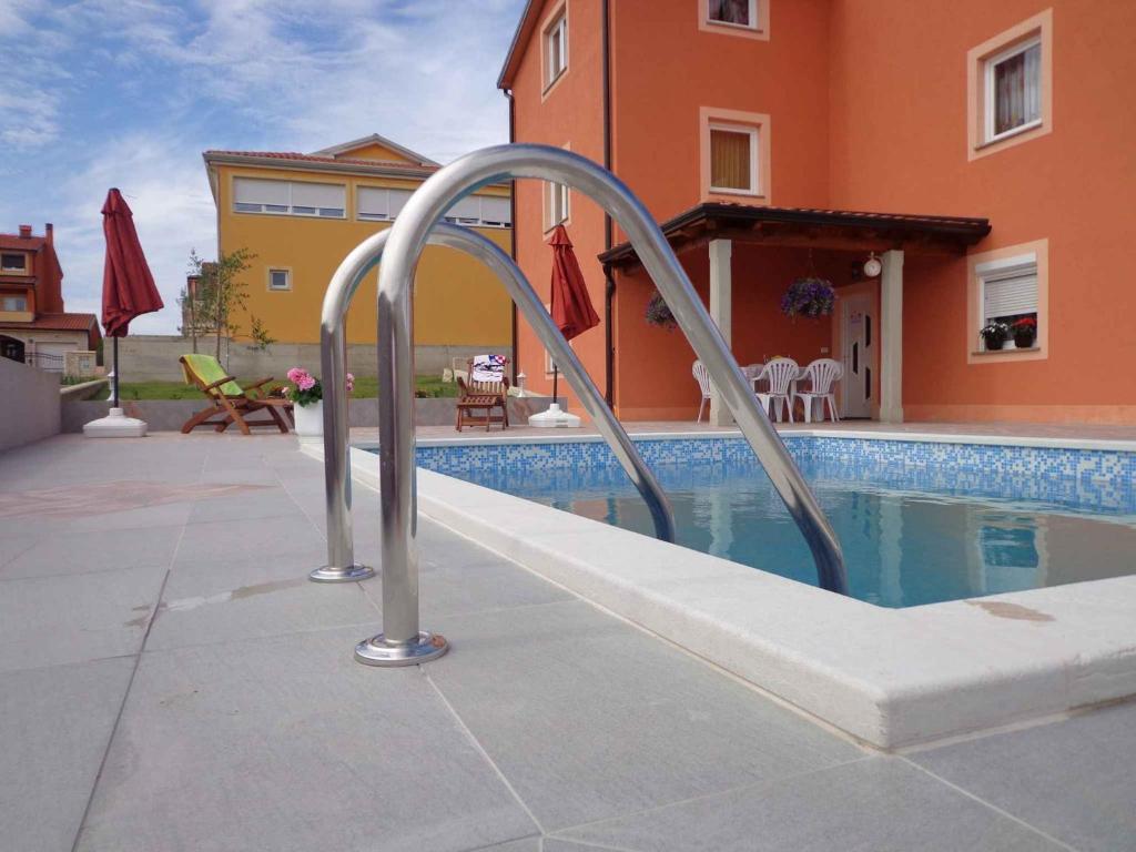 a swimming pool with a metal ladder next to a house at Apartment Kastel 22 in Kaštel
