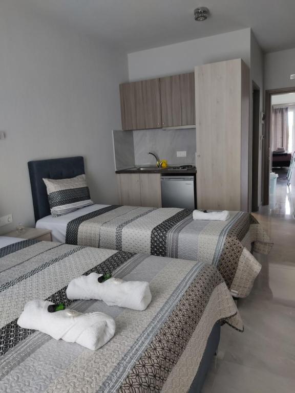 3 łóżka w pokoju z ręcznikami w obiekcie Mei's luxury apartments w Stavrós