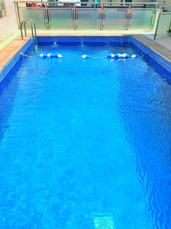 une grande piscine d'eau bleue dans l'établissement Arabs Chalet, à Buraydah