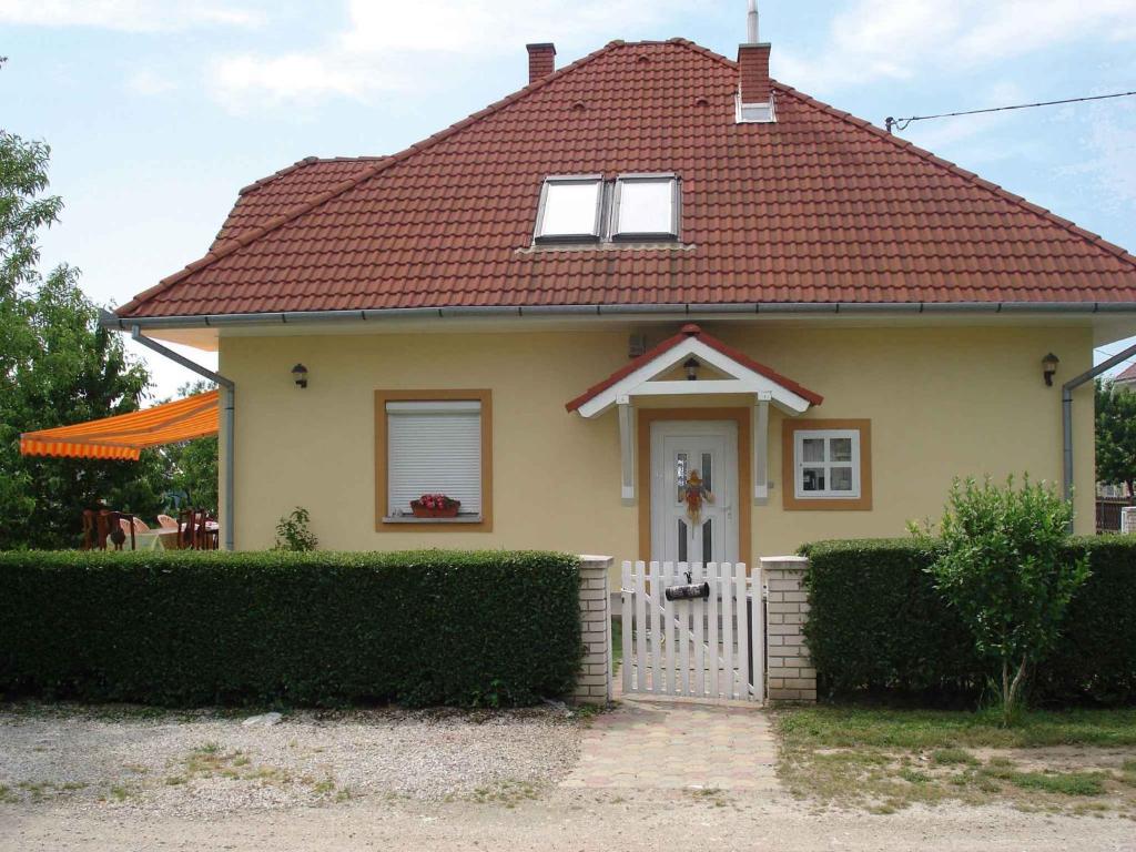 mały żółty dom z czerwonym dachem w obiekcie Apartment in Gyenesdias - Balaton 18807 w Gyenesdiás