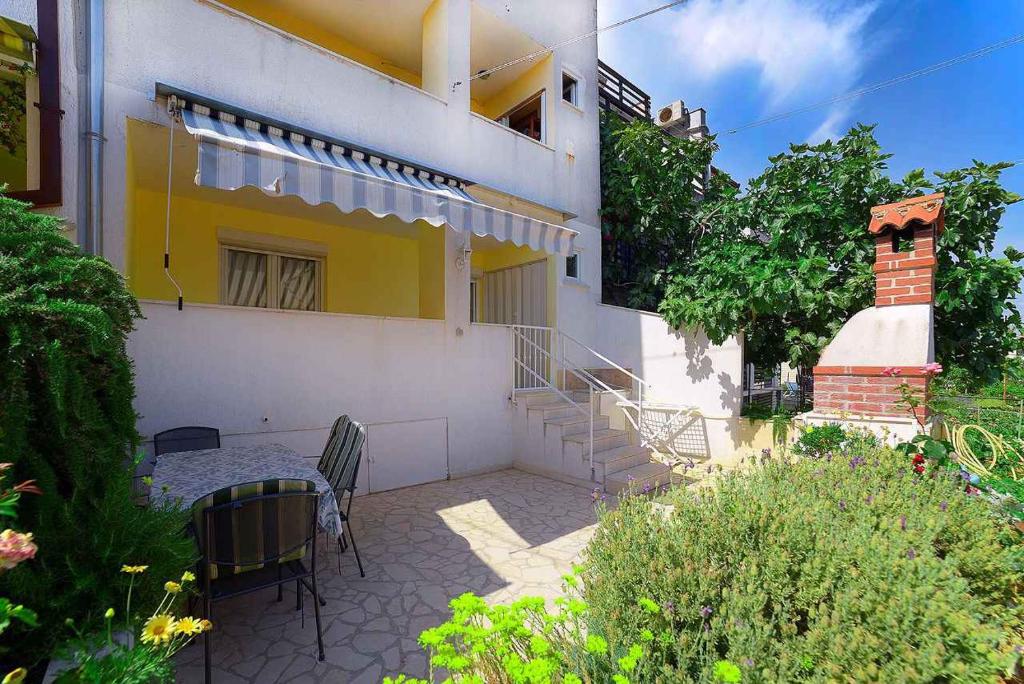 a house with chairs and a table in front of it at Apartment Pula, Istria Country 1 in Vintijan