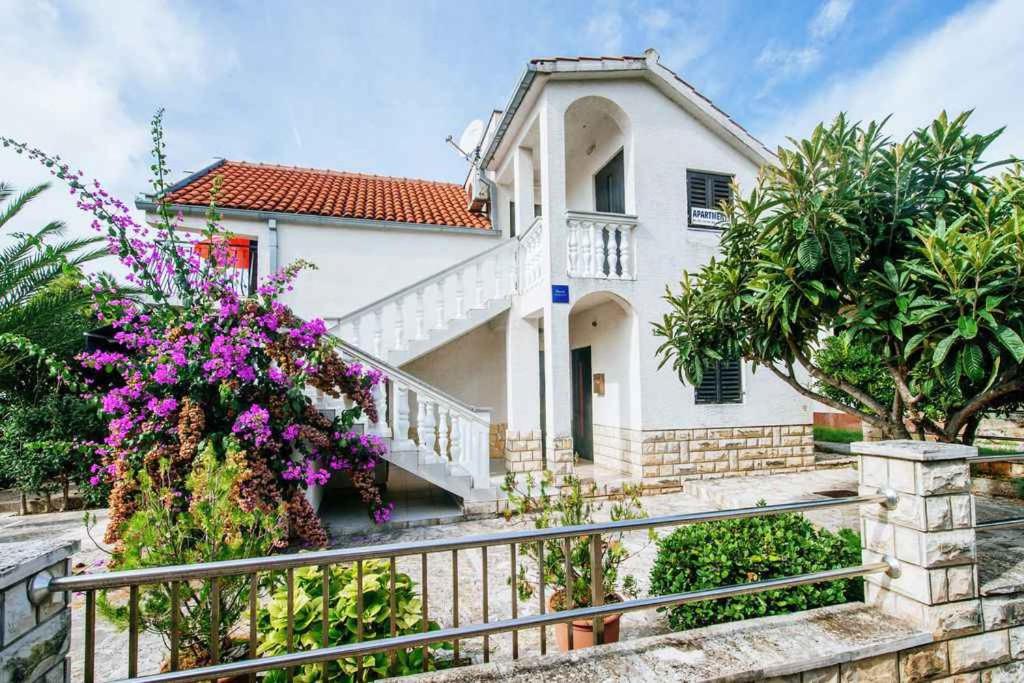 una casa blanca con flores en una valla en Apartment in Petrcane/Zadar Riviera 7842 en Petrcane