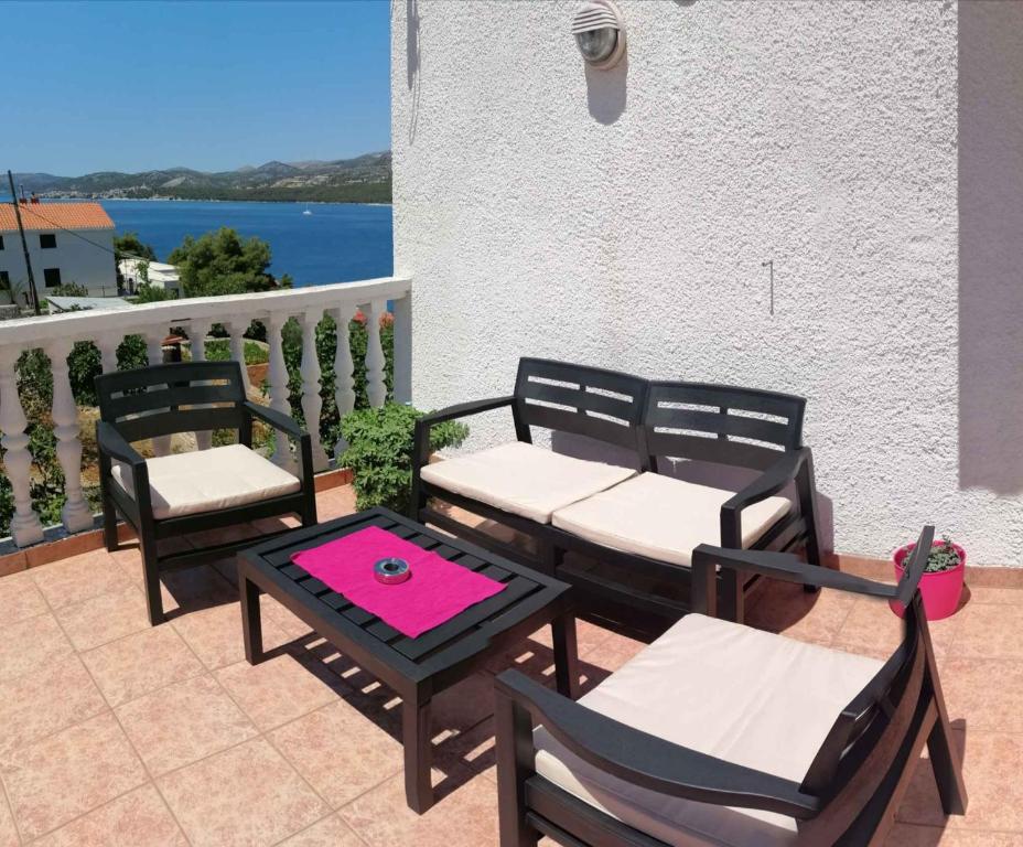 a group of chairs and tables on a patio at Apartment Trogir 6 in Okrug Donji