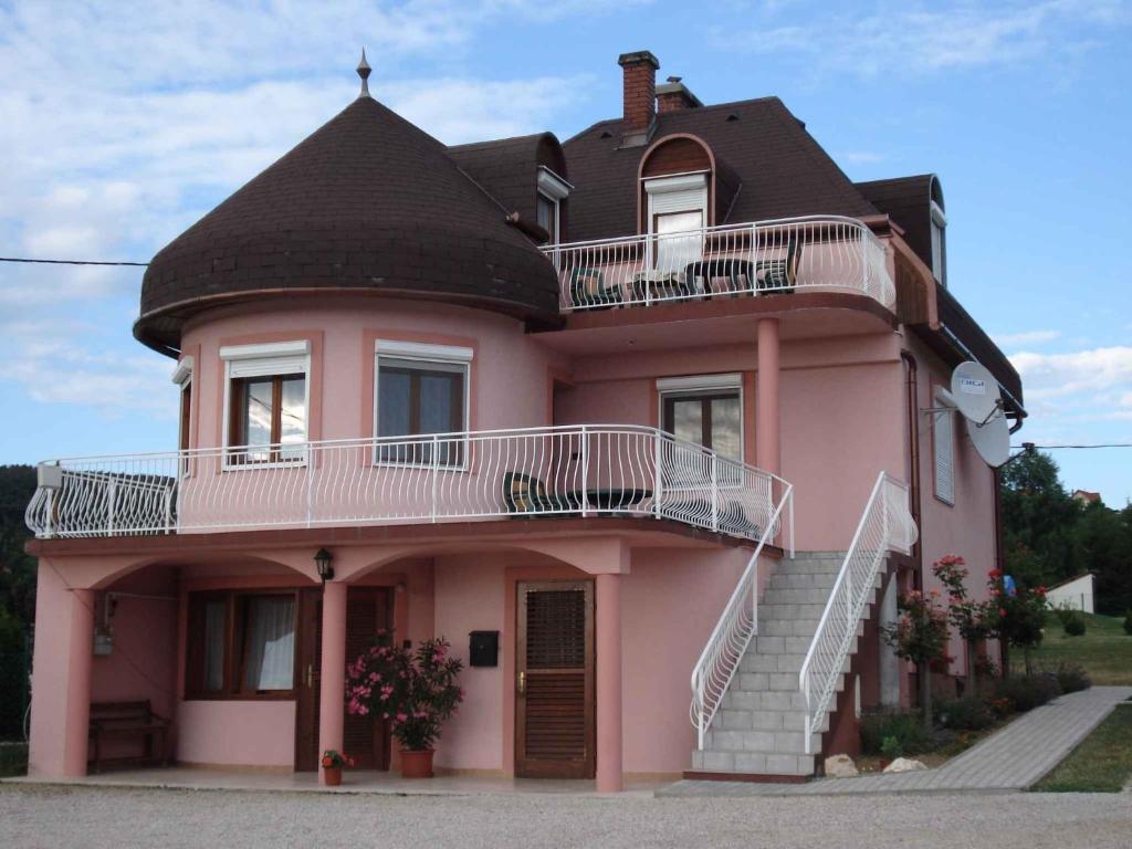 DobogómajorにあるApartments in Cserszegtomaj/Balaton 18292の黒屋根と階段のピンクの家