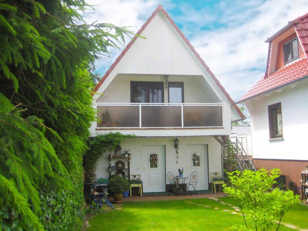 ein weißes Haus mit einem Balkon und einem Hof in der Unterkunft Holiday home Groß Kordshagen/Ostsee 2774 in Flemendorf