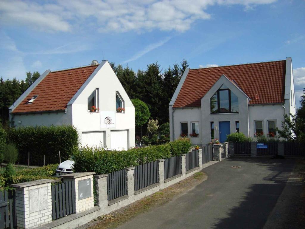 Biały dom z czerwonym dachem i płotem w obiekcie Apartment in Frantiskovy Lazně 1609 w mieście Dolní Lomany