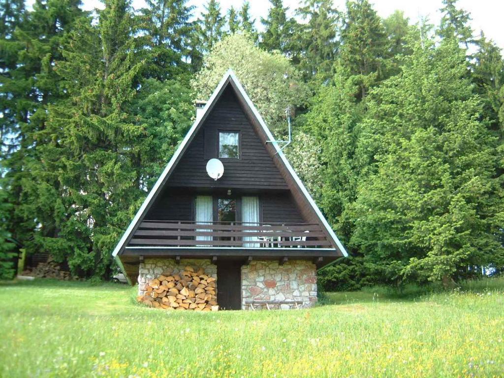 una pequeña casa con techo sobre un campo en Holiday home Strazne/Riesengebirge 2326, en Strážné