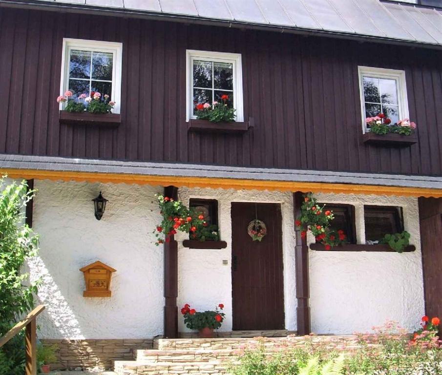 a house with flower boxes on the front of it at Apartment Herlikovice U Vrchlabi 1 in Hořejší Vrchlabí