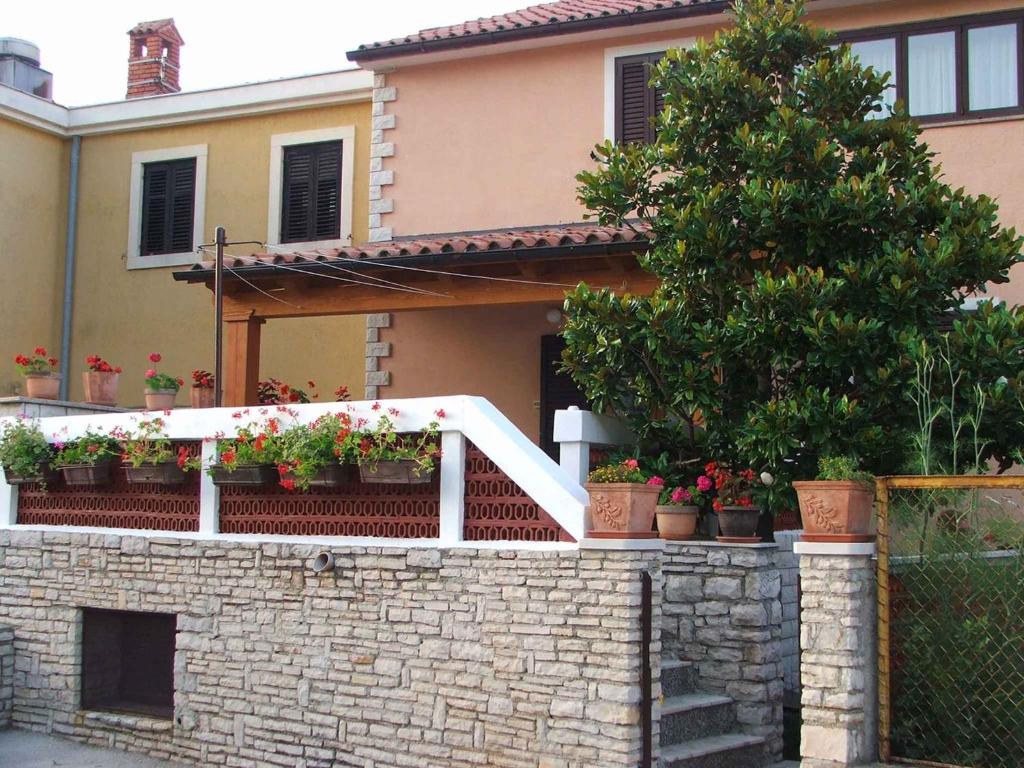 una casa con macetas en una pared de ladrillo en Apartment in Plomin/Istrien 8771 en Plomin