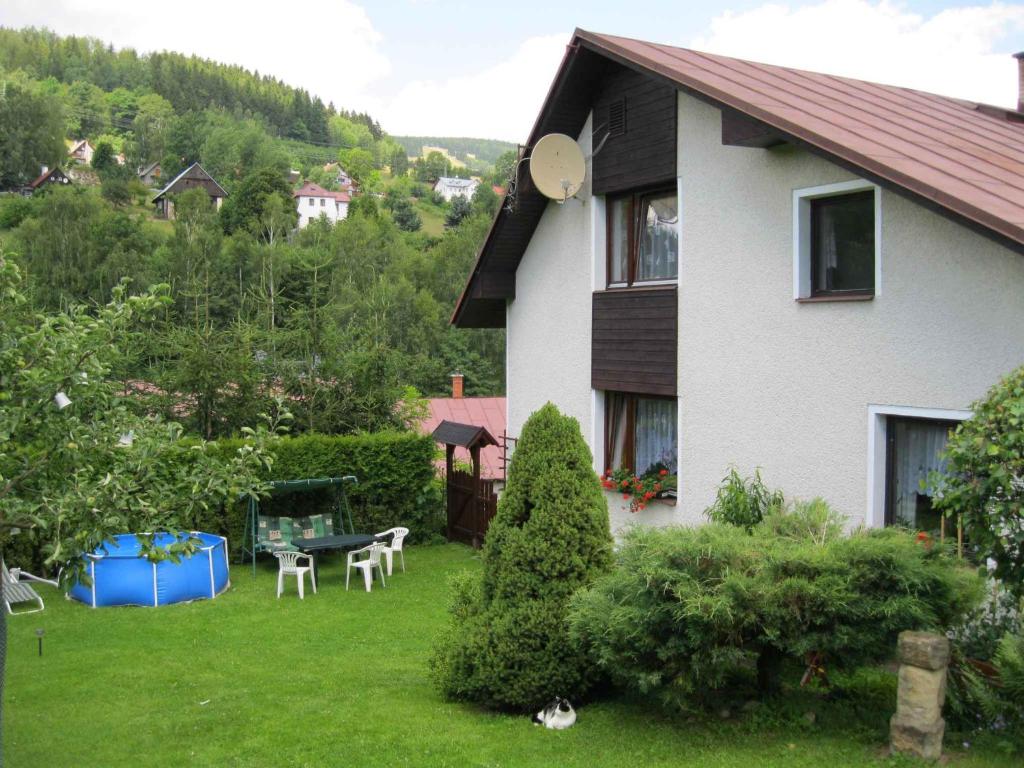 a house with a yard with a table and chairs at Apartment in Rokytnice nad Jizerou 2102 in Rokytnice nad Jizerou