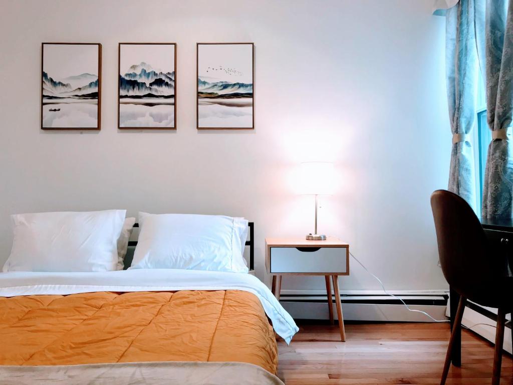 a bedroom with a bed and four pictures on the wall at Harvard Allston Campus Three-Bedroom Two Bath Executive Apartment in Boston