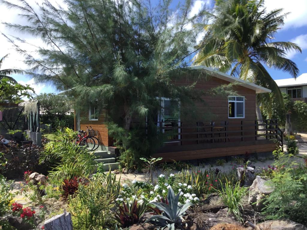 una pequeña casa con un jardín frente a ella en Matira Beach Bungalow Waterfront, en Bora Bora