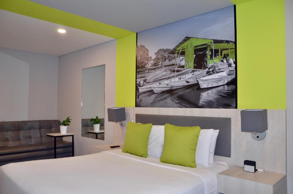 a bedroom with a bed with a painting on the wall at Suites Home 118 By SHG in Bogotá