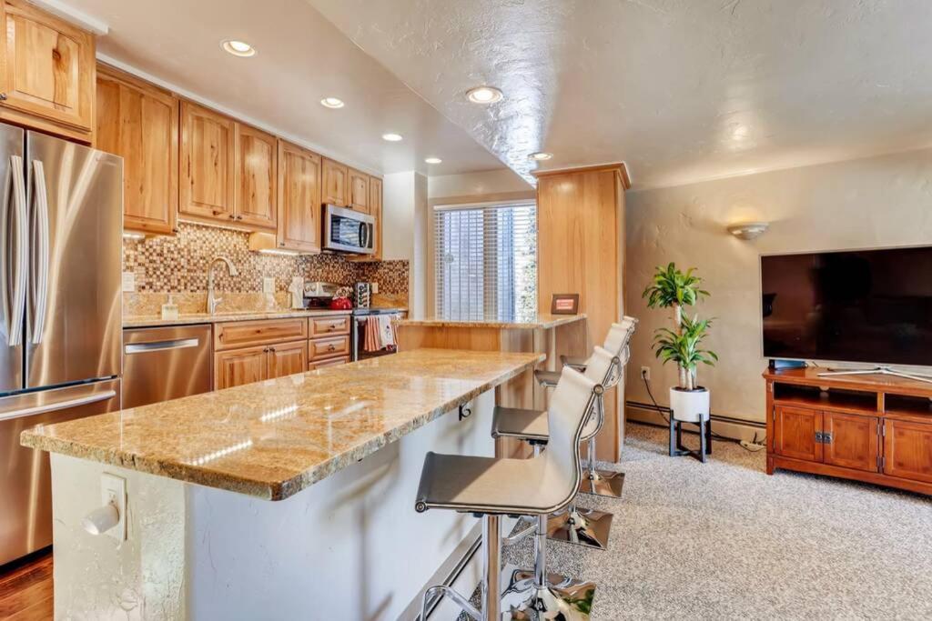 a large kitchen with wooden cabinets and a large island at Hot Tub & Sauna PEAK 8 BRECKENRIDGE in Breckenridge