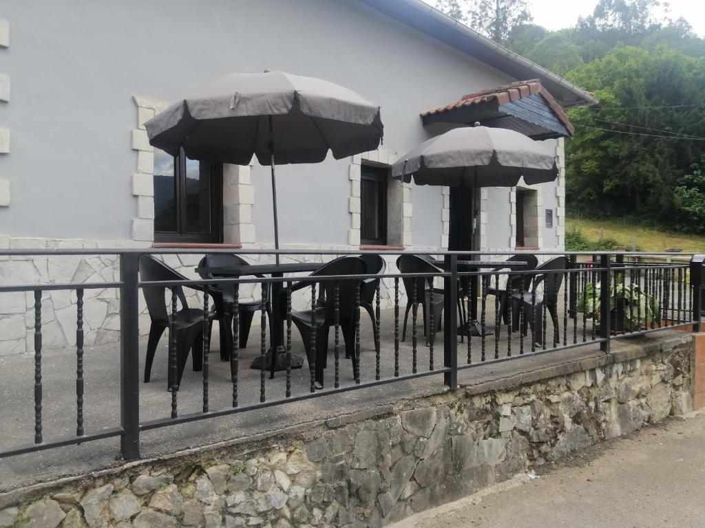 una mesa con sillas y sombrillas en una valla en Casa pando 49 en Pando