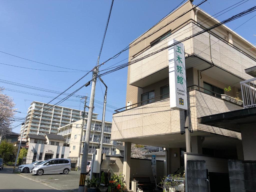 a building with a sign on the side of it at Tamaki Ryokan in Kumamoto