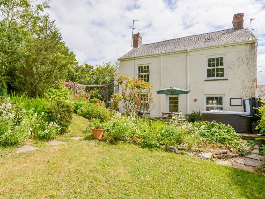 a white house with a garden in front of it at Garden Cottage in Bideford