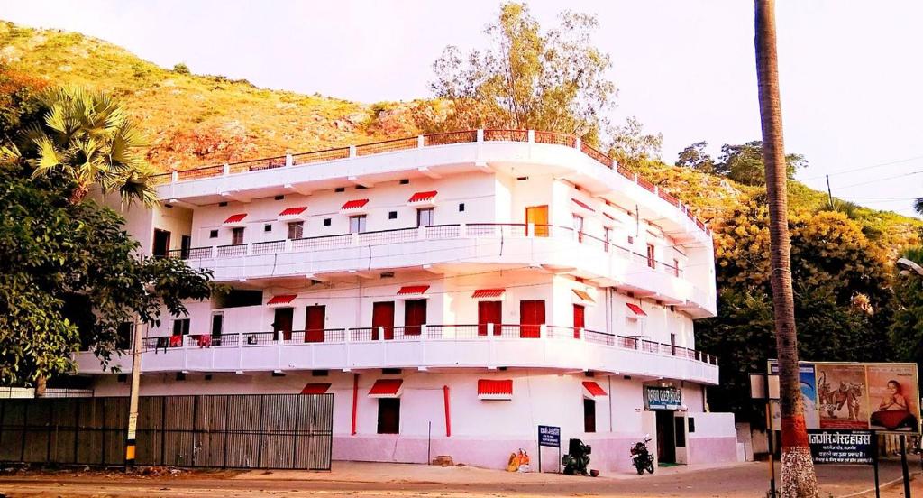 a white building with a balcony on top of it at RAJGIR INTERNATIONAL in Rājgīr
