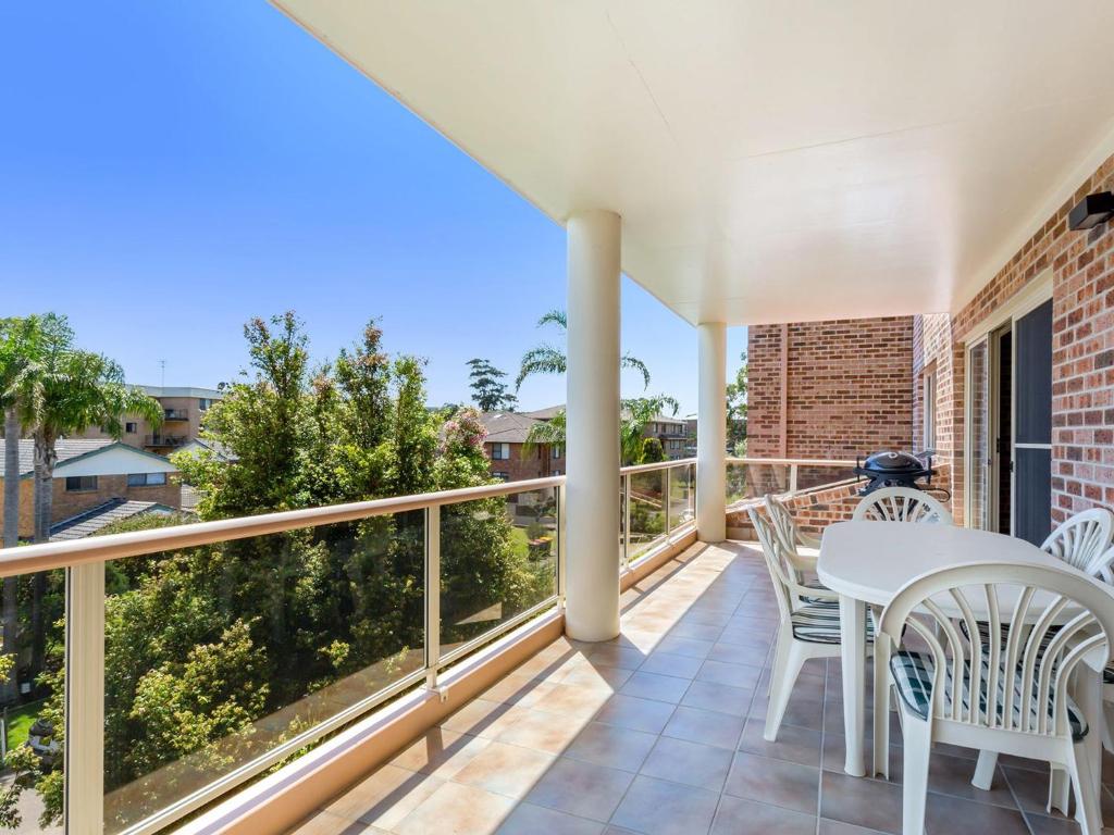 a patio with a white table and chairs on a balcony at Cottage Court 4 Shoal Bay and Little Beach at your fingertips in Nelson Bay