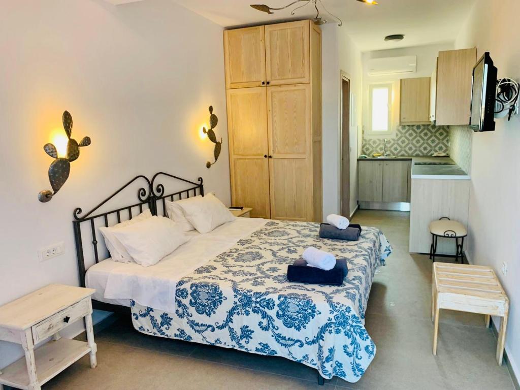 a bedroom with a large bed and a kitchen at sun studios in Mýkonos City