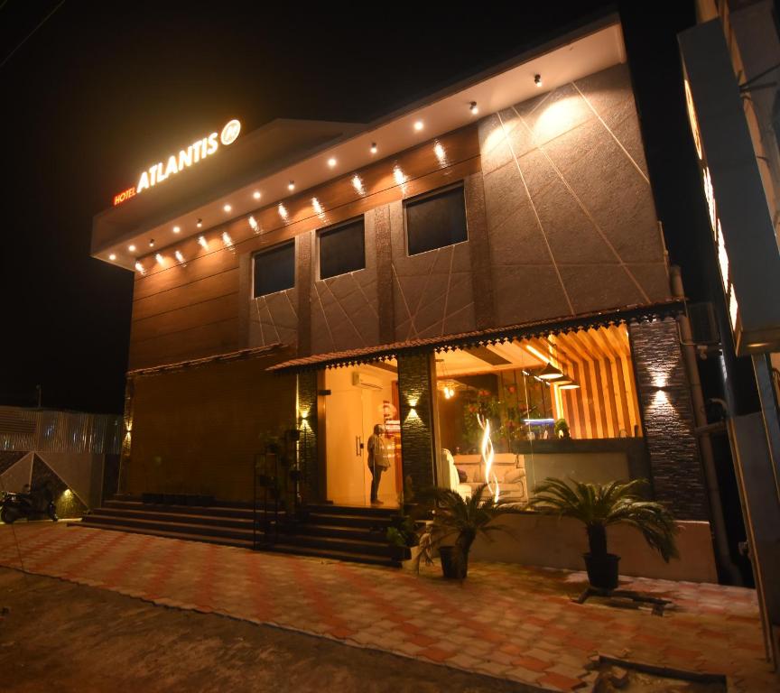 a man standing outside of a building at night at Hotel Atlantis in Kumbakonam