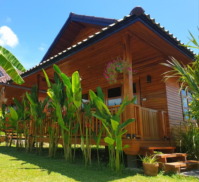 una casa de madera con plantas delante de ella en Samui Blue Bird, en Mae Nam