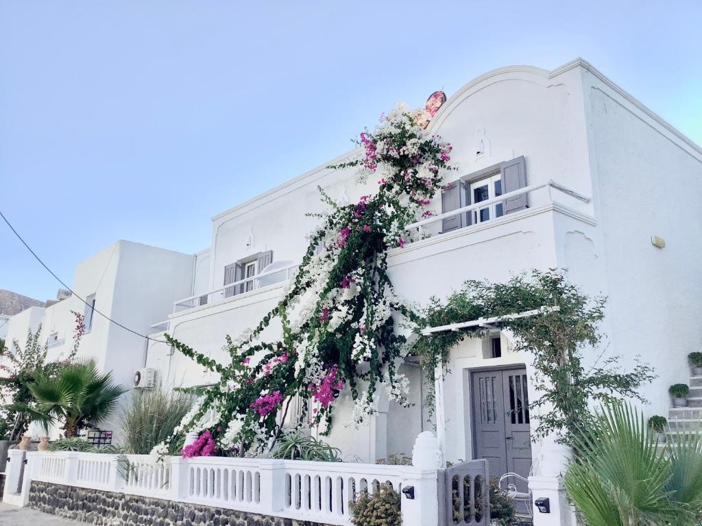 a white building with flowers on it at Villa Maina in Kamari