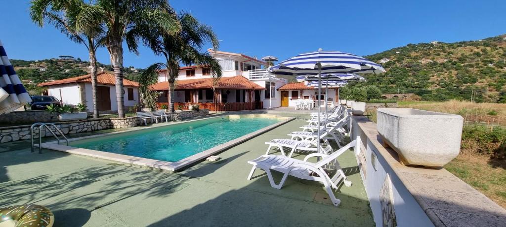 une maison dotée d'une piscine avec des chaises et un parasol dans l'établissement Villa Maria con piscina e giardino privato, à Santa Maria