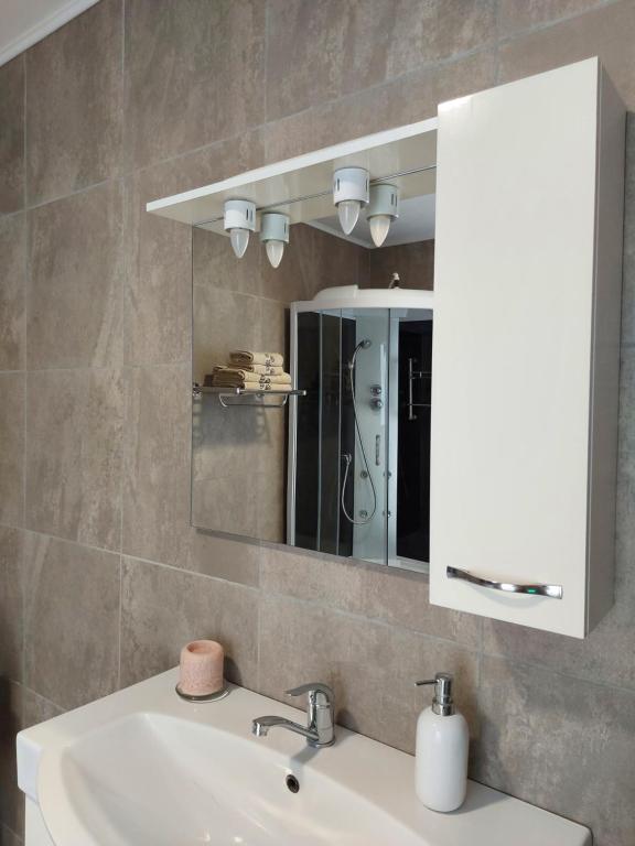 a bathroom with a sink and a mirror at Villa Romelia - Select Apartments in Vadu