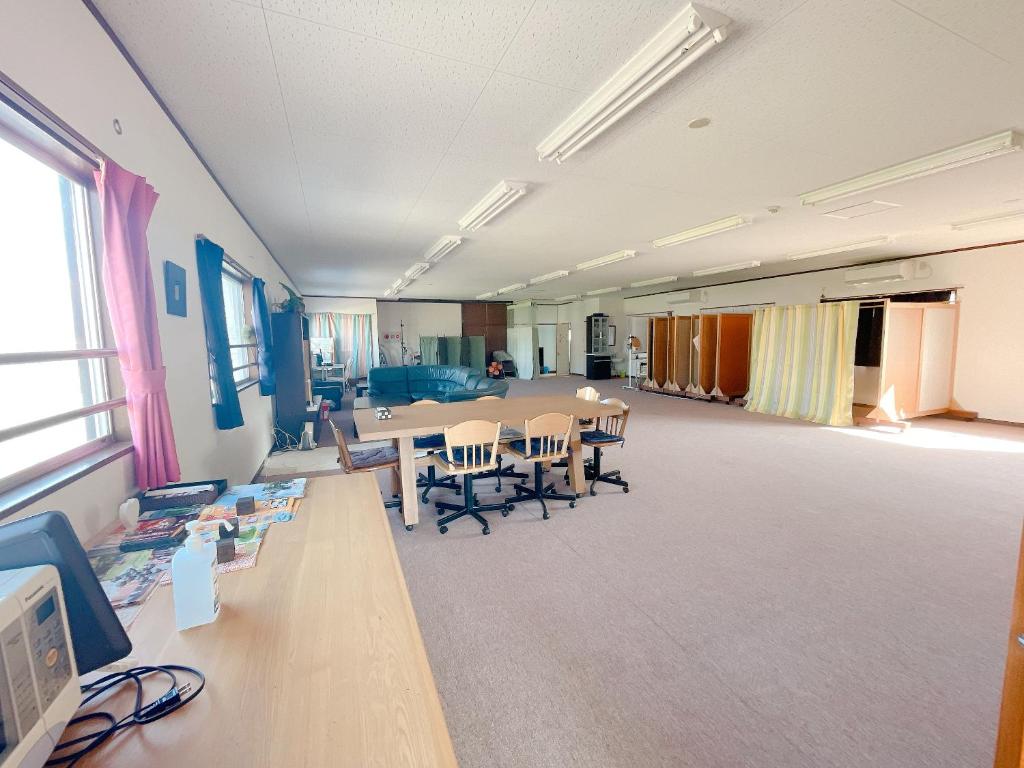 Habitación grande con mesa y sillas. en すずめのお宿 つばめの間 最大30名 Swallow room Maximum of 30 people, en Kotohira