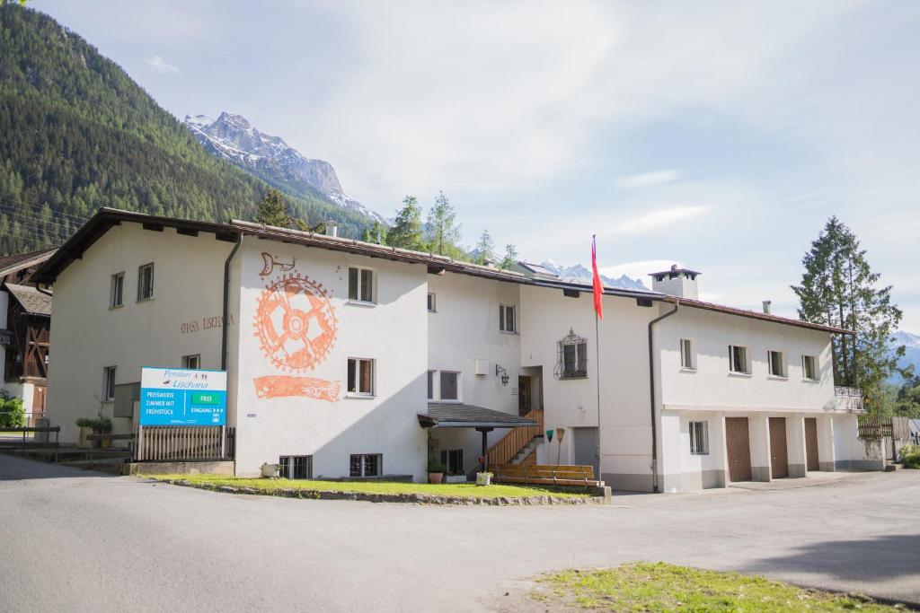 a building with a flag on the side of it at Pensiun Lischana in Sent