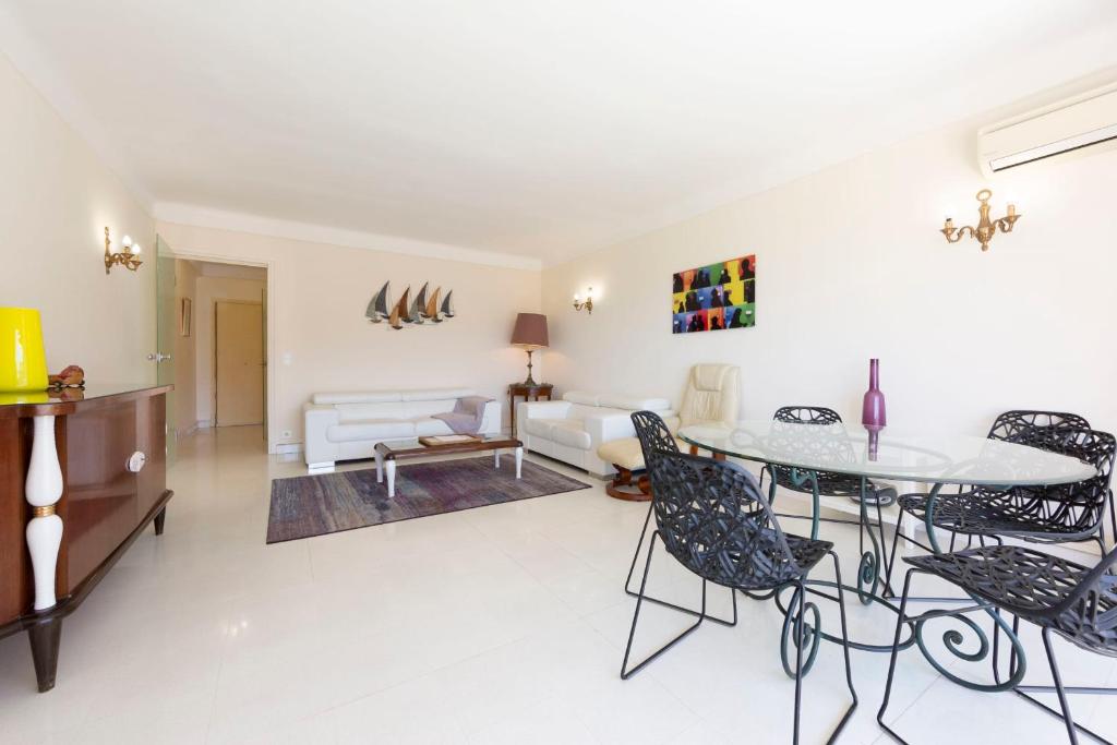 un soggiorno con tavolo e sedie di Fully equipped appartment 105 m2 clear view on the sea and californie hills a Cannes