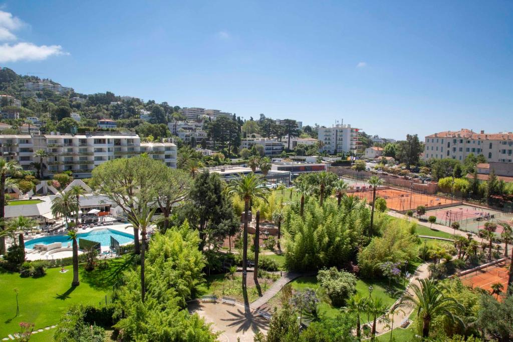 a view of a park with palm trees and buildings at Fully equipped appartment 105 m2 clear view on the sea and californie hills in Cannes